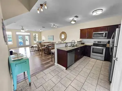 a kitchen and dining room with a table and a refrigerator at Shells and Bells Ocean Paradise - Sleeps 24, 2 Private Pools in Panama City Beach