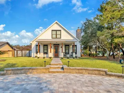 a white house with a brick driveway at Moonlight Cottage in Panama City Beach