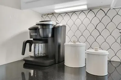a coffee maker and two cups on a counter at Moonlight Cottage in Panama City Beach