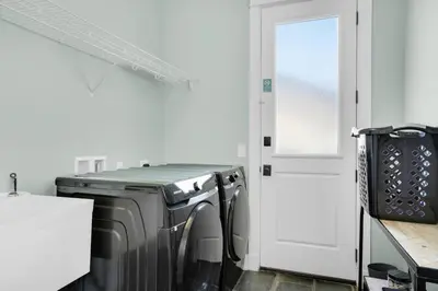 a laundry room with a washing machine and a door at Moonlight Cottage in Panama City Beach