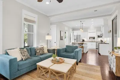 a living room with a blue couch and a table at Moonlight Cottage in Panama City Beach