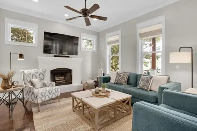a living room with blue couches and a fireplace at Moonlight Cottage in Panama City Beach