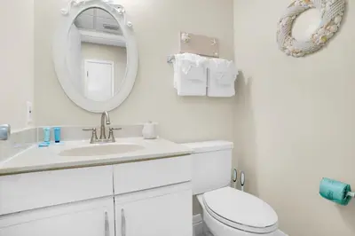 a white bathroom with a sink and a mirror at Edgewater Golf Villa 2010 in Panama City Beach
