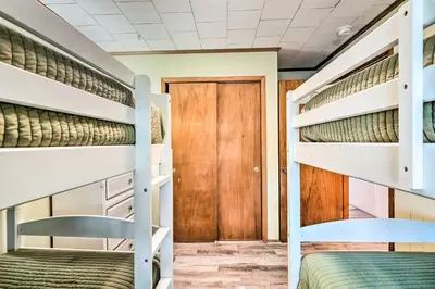 two bunk beds in a dorm room with a door at Private Bid-A-Wee Beach Access! PCB Home with Pool in Panama City Beach