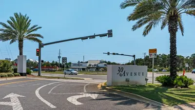 an intersection with a traffic light and a sign that says expensive at Lazy Days in Seacrest