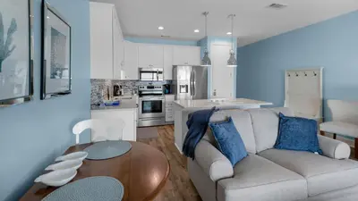 a living room with a couch and a table at Palms C14 in Santa Rosa Beach