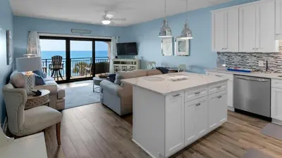 a kitchen and living room with a view of the ocean at Palms C14 in Santa Rosa Beach