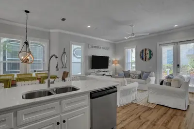 a kitchen with a sink and a living room at The Real McCoy in Panama City Beach