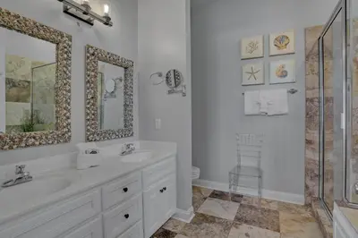 a white bathroom with a sink and a mirror at The Real McCoy in Panama City Beach