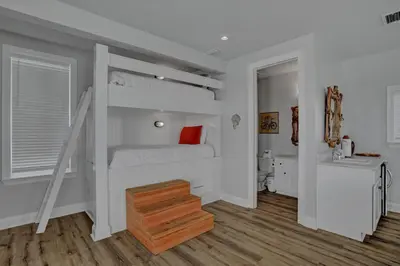 a bedroom with a bunk bed and a bathroom at The Real McCoy in Panama City Beach