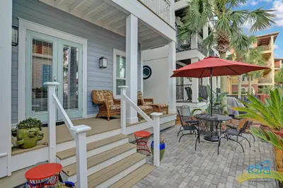 a porch with a table and an umbrella at The Real McCoy in Panama City Beach