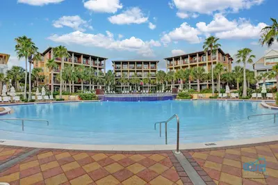 a large swimming pool in a resort with palm trees at The Real McCoy in Panama City Beach