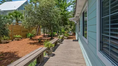 a wooden walkway next to a house with benches at 171 Seacrest in Seacrest