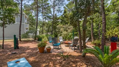 a backyard with chairs and a table and trees at 171 Seacrest in Seacrest