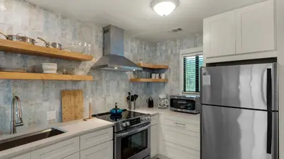 a kitchen with white cabinets and a stainless steel refrigerator at Hidden Beach 219 in Santa Rosa Beach