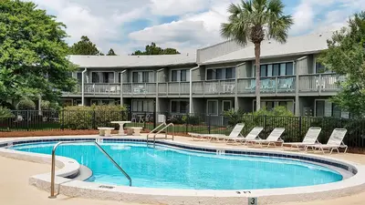a pool in front of a hotel with chairs and a building at Hidden Beach 219 in Santa Rosa Beach