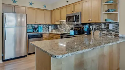 a kitchen with a stainless steel refrigerator and wooden cabinets at Beachcrest 1204 in Santa Rosa Beach