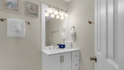 a white bathroom with a sink and a mirror at Beacons 1 in Santa Rosa Beach