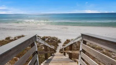 a boardwalk to the beach with the ocean in the background at Beacons 1 in Santa Rosa Beach