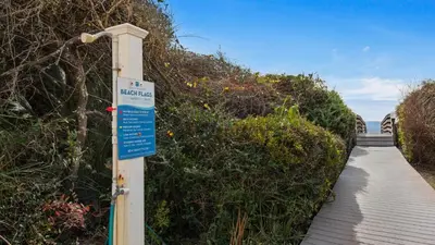a sign on a wooden walkway next to a boardwalk at Beacons 1 in Santa Rosa Beach