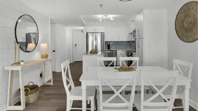 a white kitchen with a white table and chairs at Beachcrest 204 in Santa Rosa Beach