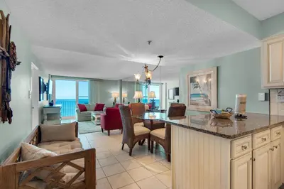 a kitchen and living room with a table and chairs at Beachcrest 703 in Santa Rosa Beach