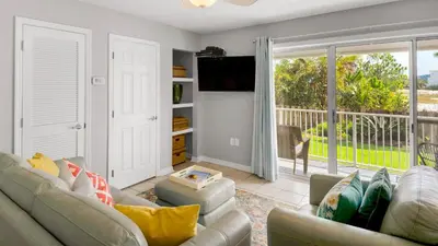 a living room with a couch and a sliding glass door at Beachside Villas 411 in Santa Rosa Beach