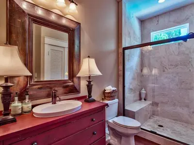 a bathroom with a toilet and a sink and a shower at Southern Grounds in Santa Rosa Beach