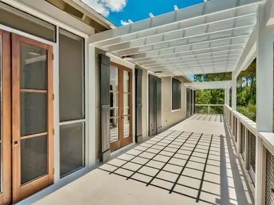an empty porch of a house with a pergola at Southern Grounds in Santa Rosa Beach