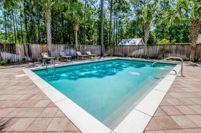 a swimming pool in a backyard with a fence at Southern Grounds in Santa Rosa Beach