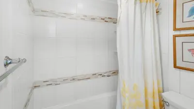 a bathroom with a tub and a shower curtain at Beachcrest 304 in Santa Rosa Beach