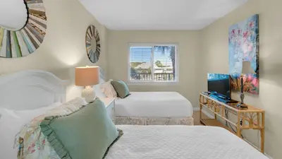 a hotel room with two beds and a television at Beachcrest 304 in Santa Rosa Beach
