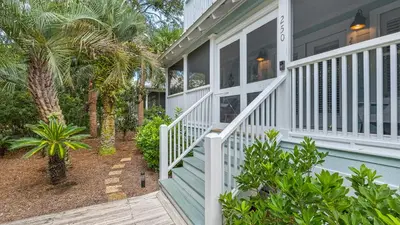 a blue house with a porch and stairs at La Pointe in Santa Rosa Beach