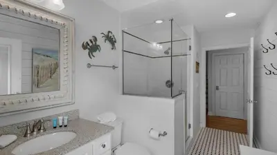 a white bathroom with a sink and a mirror at La Pointe in Santa Rosa Beach