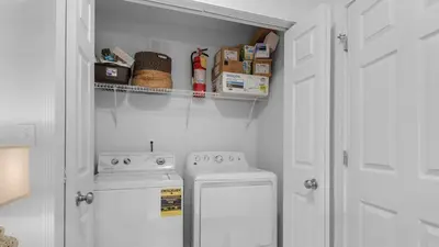 a small kitchen with a stove and a washer at La Pointe in Santa Rosa Beach
