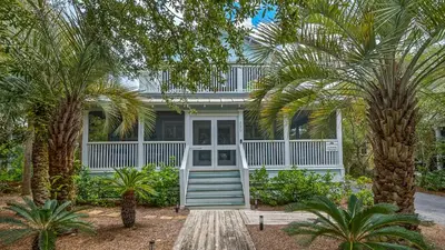 a house with palm trees in front of it at La Pointe in Santa Rosa Beach