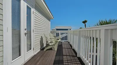 a balcony of a house with a table and benches at Sea Turtle Pass in Santa Rosa Beach