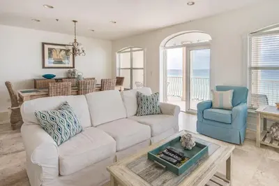 a living room with a white couch and a blue chair at Villas At Sunset Beach A302 - Sunset Villa in Rosemary Beach