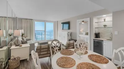 a kitchen and living room with a table and chairs at Beachcrest 402 in Santa Rosa Beach