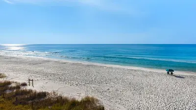 a person standing on a beach with an umbrella at Beachcrest 402 in Santa Rosa Beach