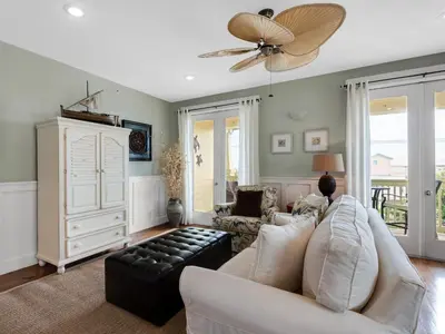 a living room with a white couch and a ceiling fan at Grand Isle 304 in Santa Rosa Beach