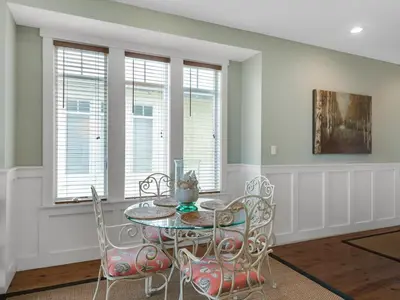 a dining room with a table and chairs and windows at Grand Isle 304 in Santa Rosa Beach