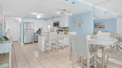 a kitchen with a white table and white chairs at Beachcrest 406 in Santa Rosa Beach