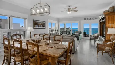 a dining room and living room with a table and chairs at Grand Playa 401 in Santa Rosa Beach