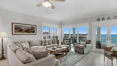 a living room with a couch and chairs and windows at Grand Playa 401 in Santa Rosa Beach