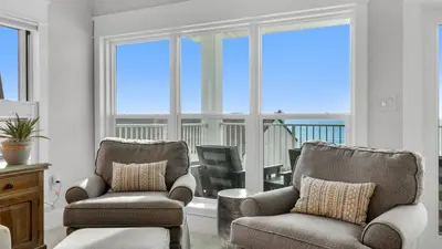a living room with two chairs and a television at Grand Playa 401 in Santa Rosa Beach