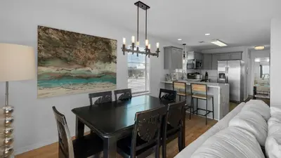 a dining room and kitchen with a table and a couch at Beachside Villas 621 in Santa Rosa Beach