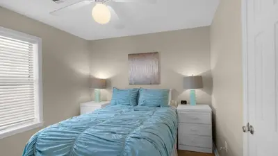a bedroom with a bed with blue sheets and a window at Beachside Villas 621 in Santa Rosa Beach