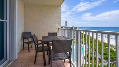 a balcony with a table and chairs and the ocean at Beachcrest 601 in Santa Rosa Beach