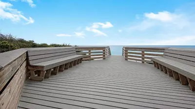 a wooden boardwalk with two benches on the beach at Hidden Beach 101 in Santa Rosa Beach
